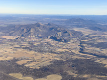 aerial view over a mountain and flat landscape 
