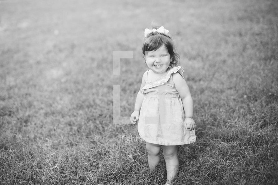 smiling toddler girl in grass