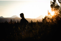 silhouette of a girl standing outdoors at sunset 