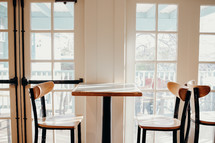 empty dinette table and chairs in front of a window 