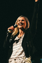 a woman on stage holding a microphone 