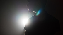 silhouette of a man standing in a spotlight 