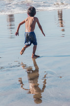 boy child running in the tide 