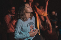 women in a congregation singing to worship music 
