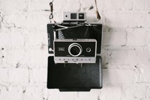 Camera hanging on a brick wall.
