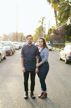 a couple standing in the middle of a LA street 