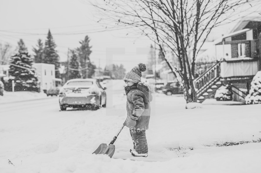 a boy shoveling snow 