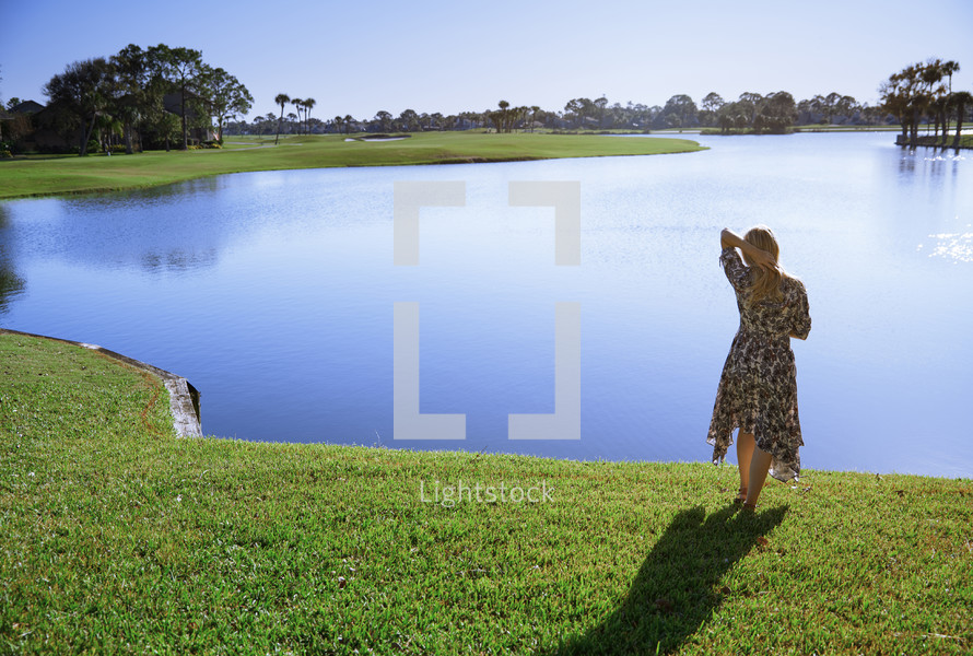 Retro styled woman standing at the lake