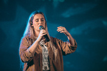 a woman holding a microphone on stage 