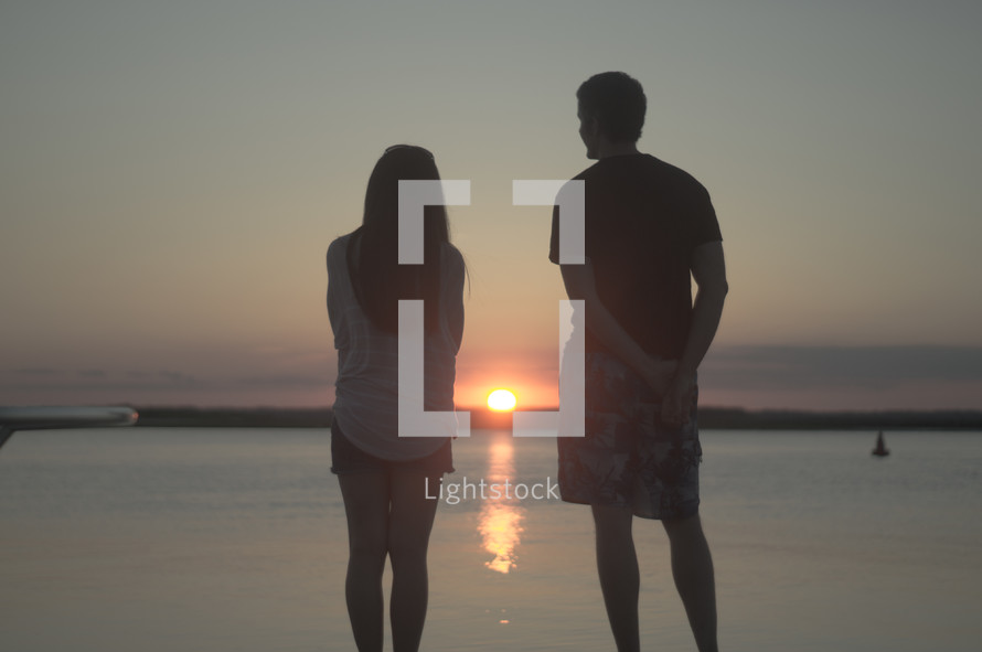 couple watching a sunset over the ocean 