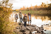 family standing on riverbanks 