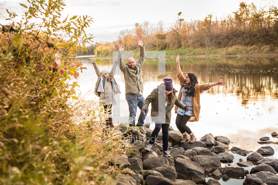 family having fun together outdoors by a river 