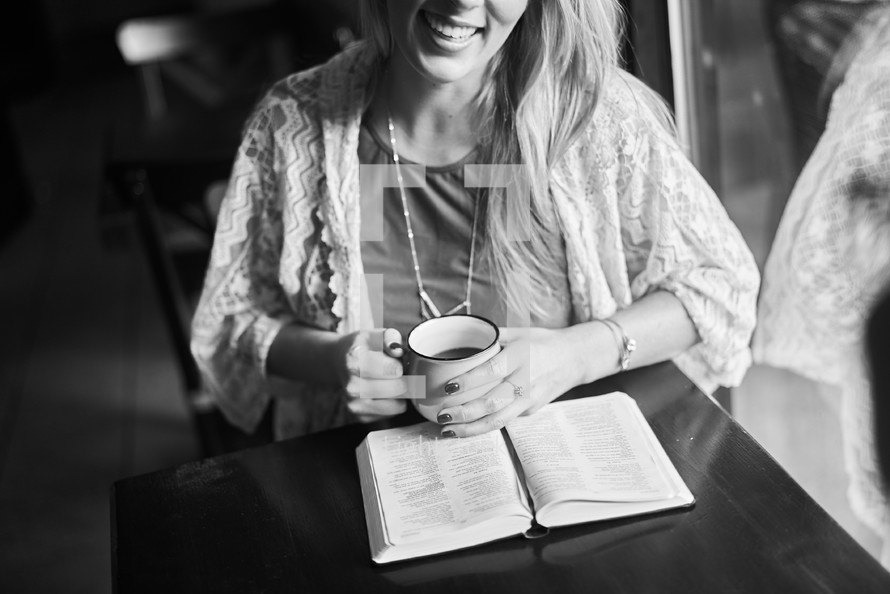 a woman reading a Bible in a coffee shop 
