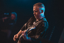 a man playing a guitar on stage 