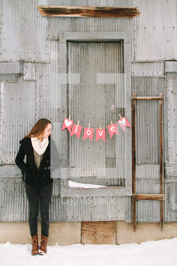 a girl standing near a love banner 