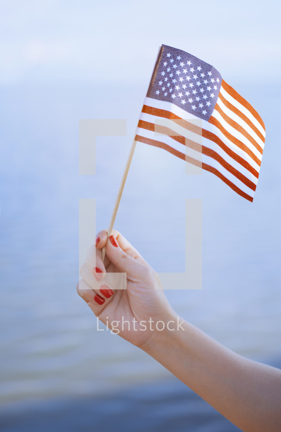 arm holding up an American flag 