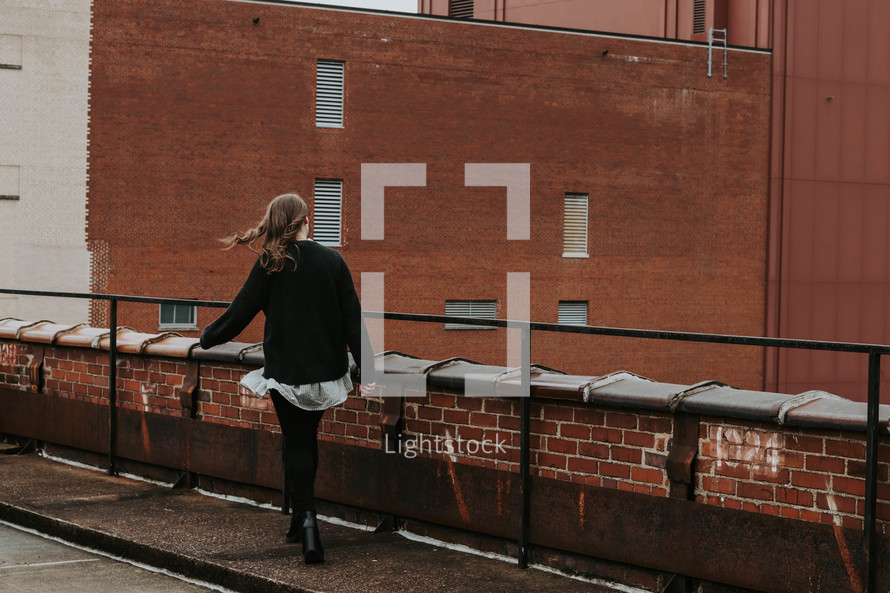 a woman walking on a rooftop 