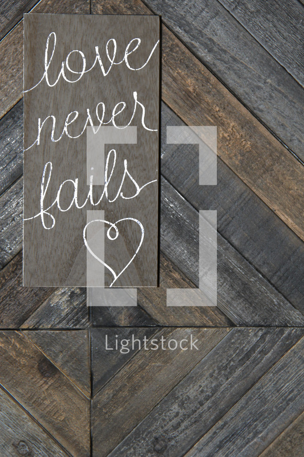 love never fails on wooden background