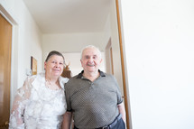 an elderly couple standing in a hallway 