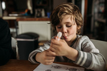 boy coloring on a coloring page at home 