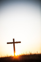 Cross on a hill at sunrise.
