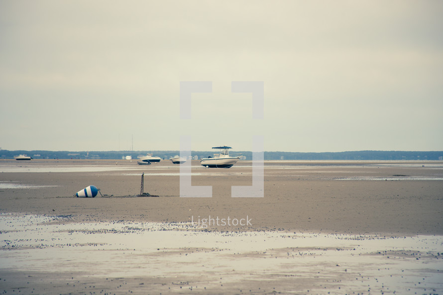 boats on a dry lake beached on the sand 