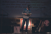 man reading a Bible at a contemporary worship service 