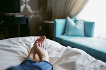 woman's feet lying in bed 