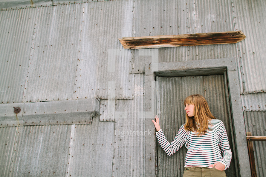a woman standing in front of a sheet metal building 
