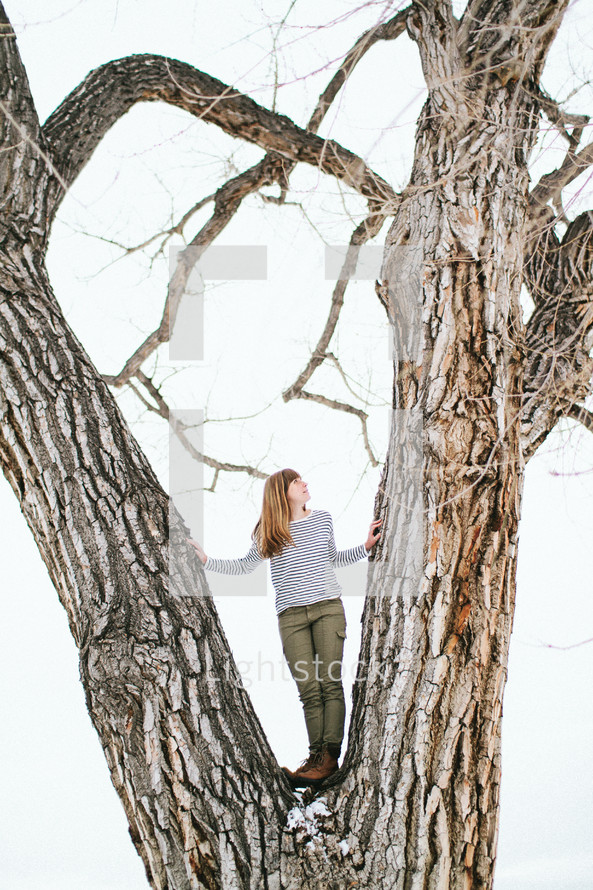a woman standing between a tree
