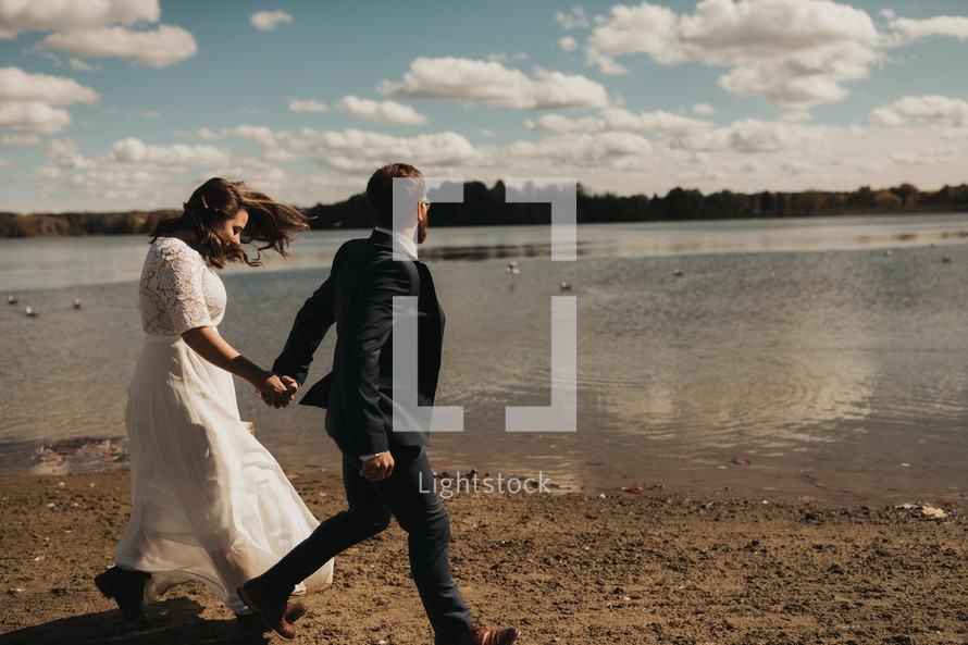 bride and groom walking on a beach 