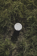 a coffee cup in the grass 