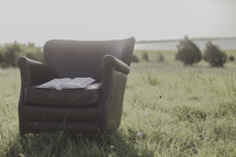 an open Bible in a leather chair outdoors 