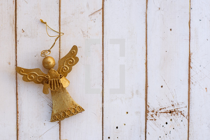 gold angel ornament on white boards 