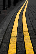 yellow lines on cobblestone street 