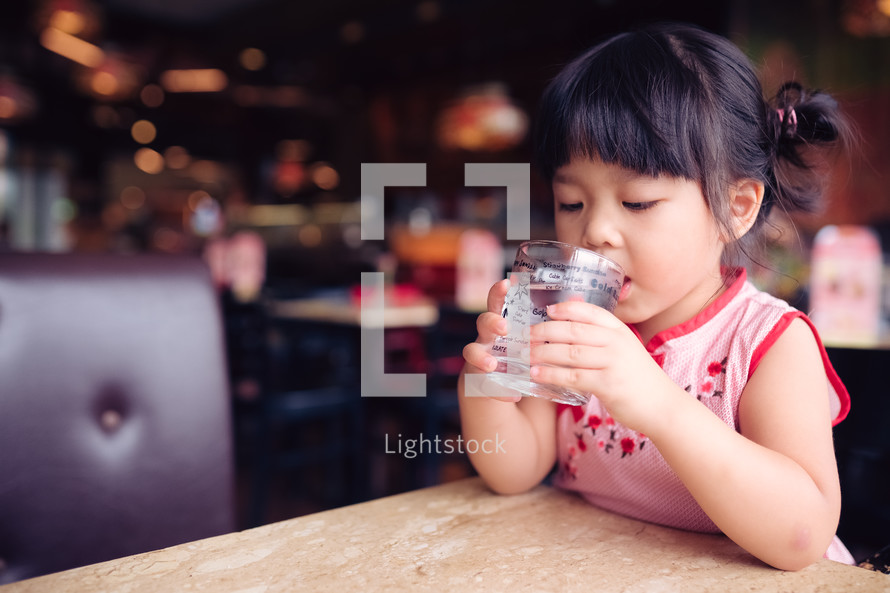 girl drinking water from a glass 