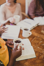 women reading Bibles and drinking coffee at a Bible study
