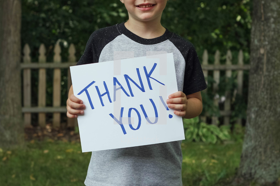 child holding a thank you sign 