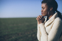 woman in prayer in a field