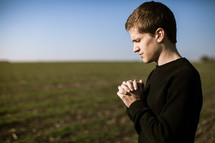 man in prayer in a field