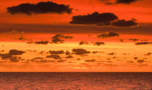 clouds in a red sky over the ocean at sunset 