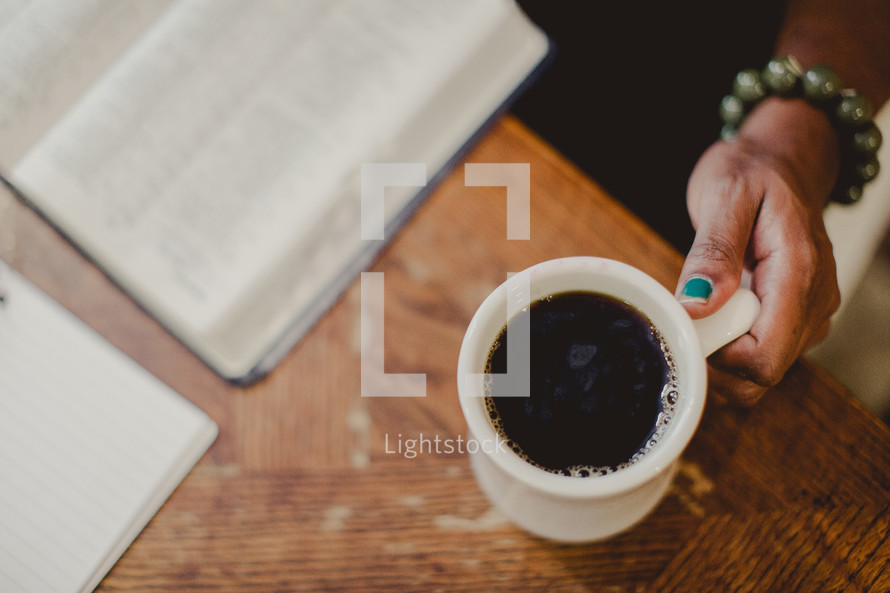 woman reading a Bible and a mug of coffee