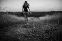 a woman walking down a worn path 