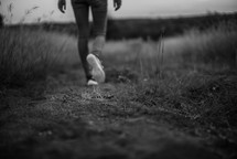 legs of a woman walking on a worn path 