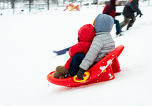 kids sledding in the snow 