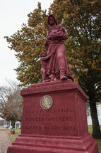 Red statue of the Pioneer Mothers of the Covered Wagon Days - US History