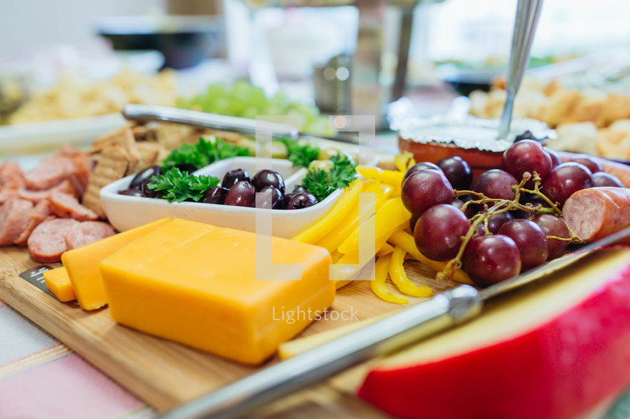 cheese, meat, and grapes on a tray 