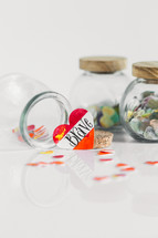 Jars of paper hearts on a white background with one lettered BRAVE in front.