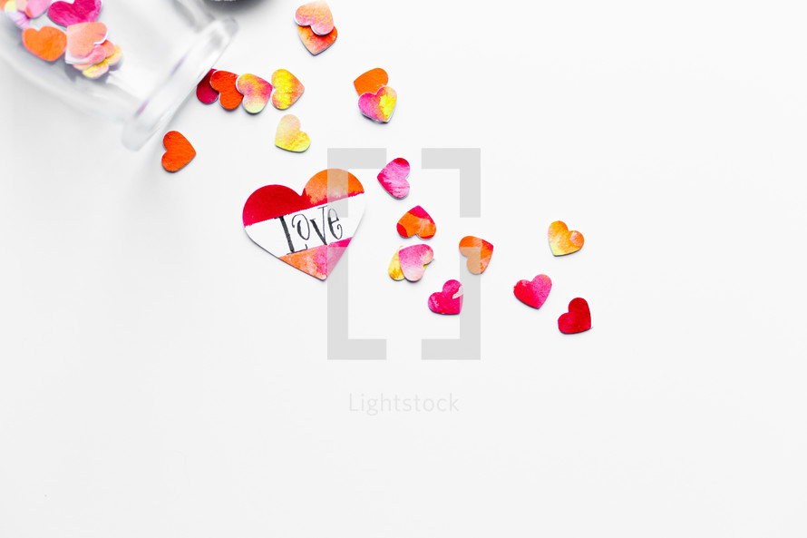 Top view of watercolor hearts scattered on white background with one labeled LOVE. 