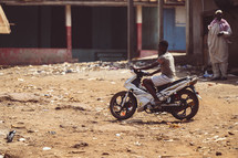 African men driving a motorcycle a small village in the Ivory Coast in west Africa